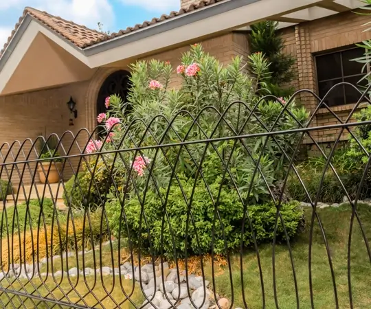 Reja Deacero Clásica frente a la fachada de una casa con un jardín